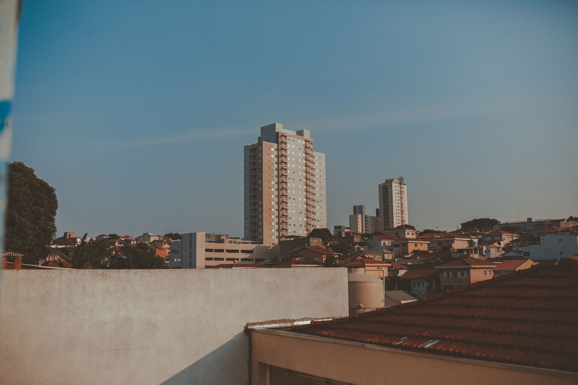 A scenic view of a city skyline with residential high-rise buildings under a clear sky at dusk.