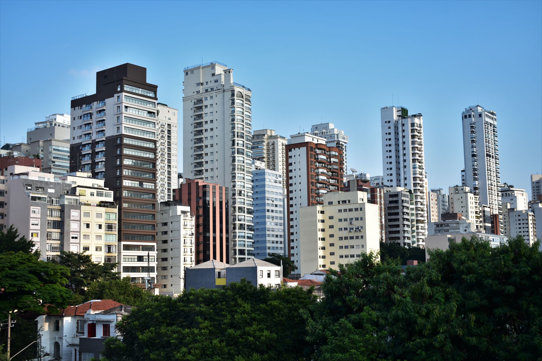 A vibrant cityscape showcasing modern high-rise buildings against a clear blue sky.
