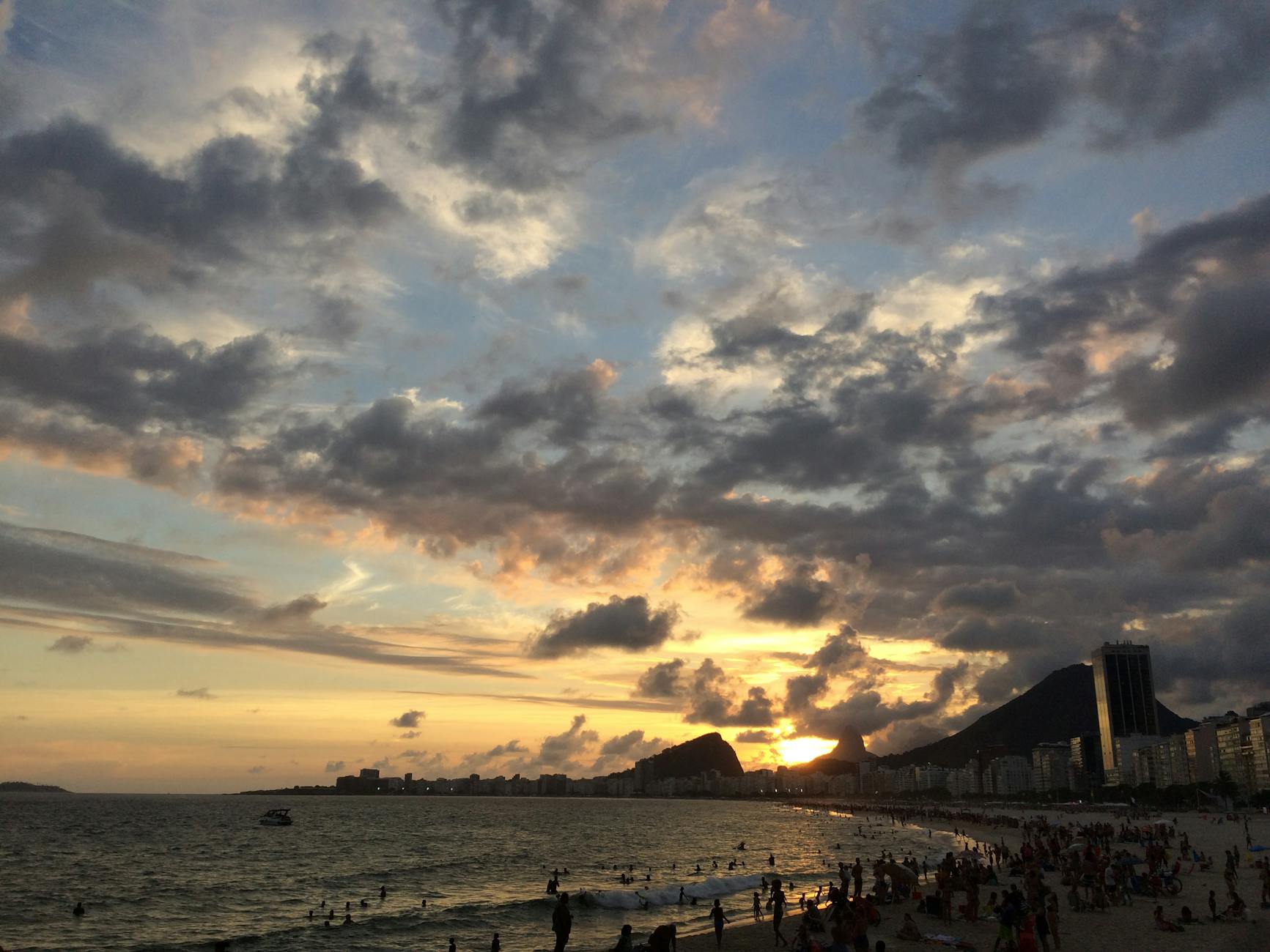 Beautiful sunset at Copacabana Beach, Rio de Janeiro, with vibrant skies and cityscape.