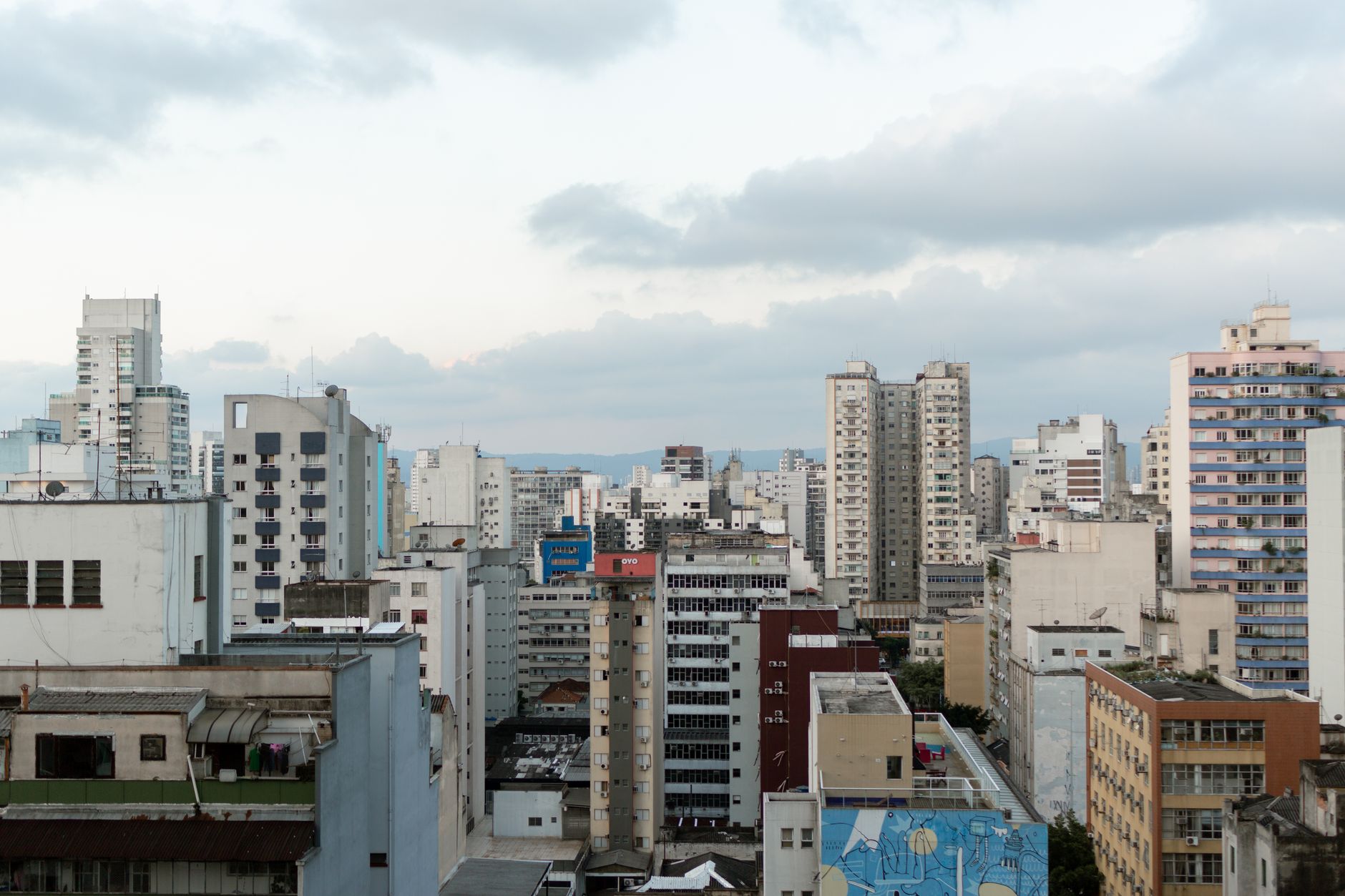 Aerial view of São Paulo's skyline with diverse urban architecture under cloudy skies.