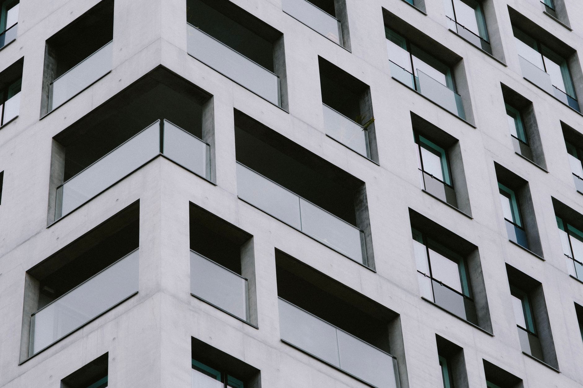 Close-up view of a modern apartment building featuring a geometric glass facade.