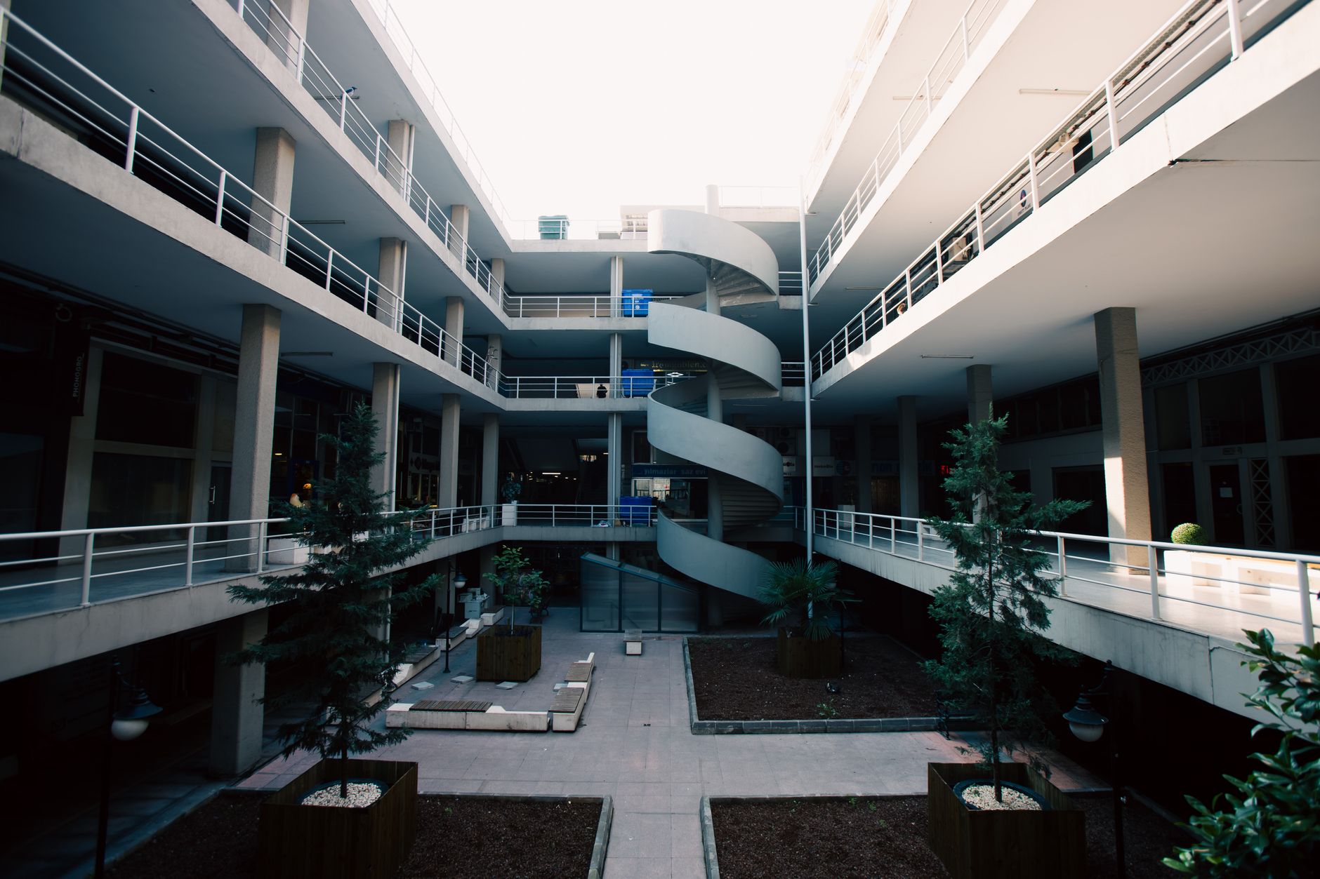 An open-air modern building with a central spiral staircase and courtyard in İstanbul, Türkiye.