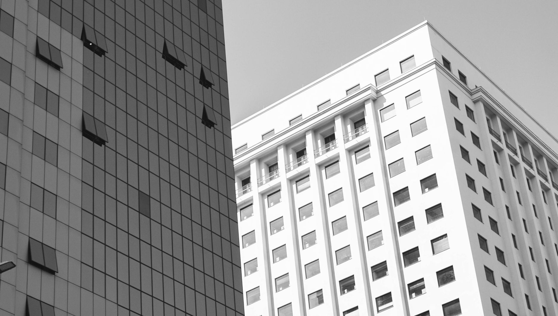Black and white capture of modern skyscraper architecture with windows. Urban cityscape view.