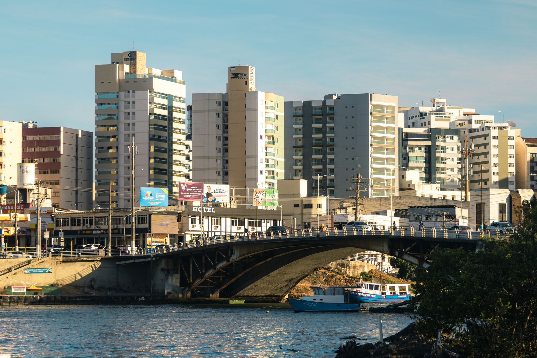 Cityscape featuring modern architecture, bridge, and river under daylight.