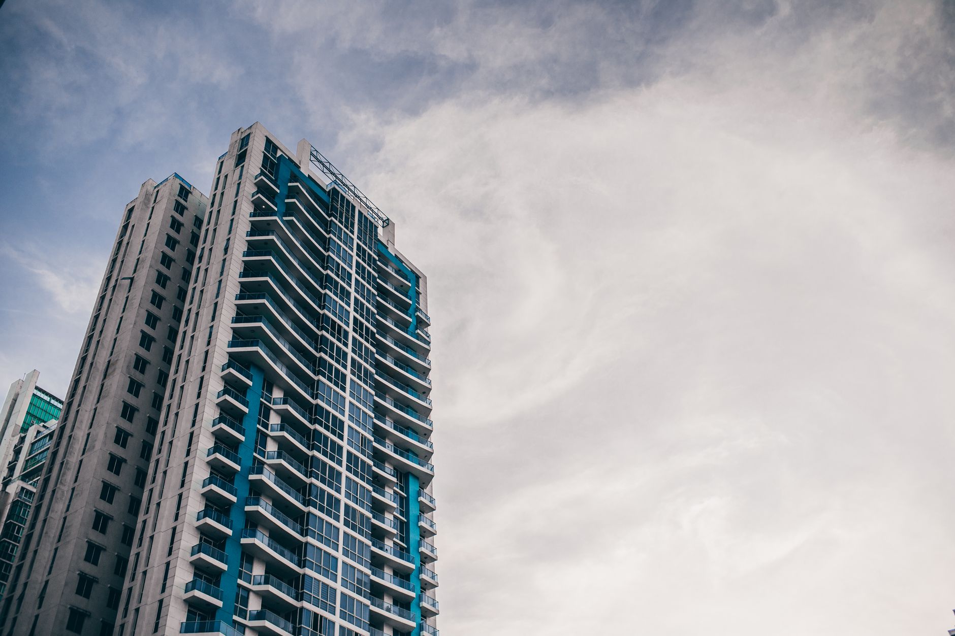 High-rise building with modern architecture reaching into a cloudy sky.