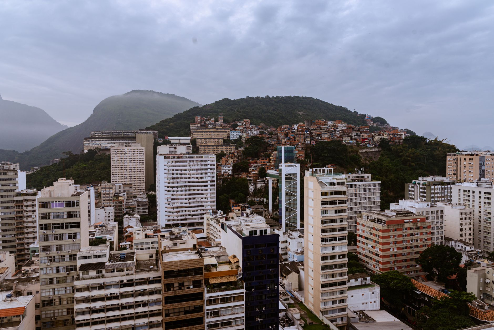 Aerial cityscape of Rio de Janeiro showcasing urban skyline and hillside residential areas.