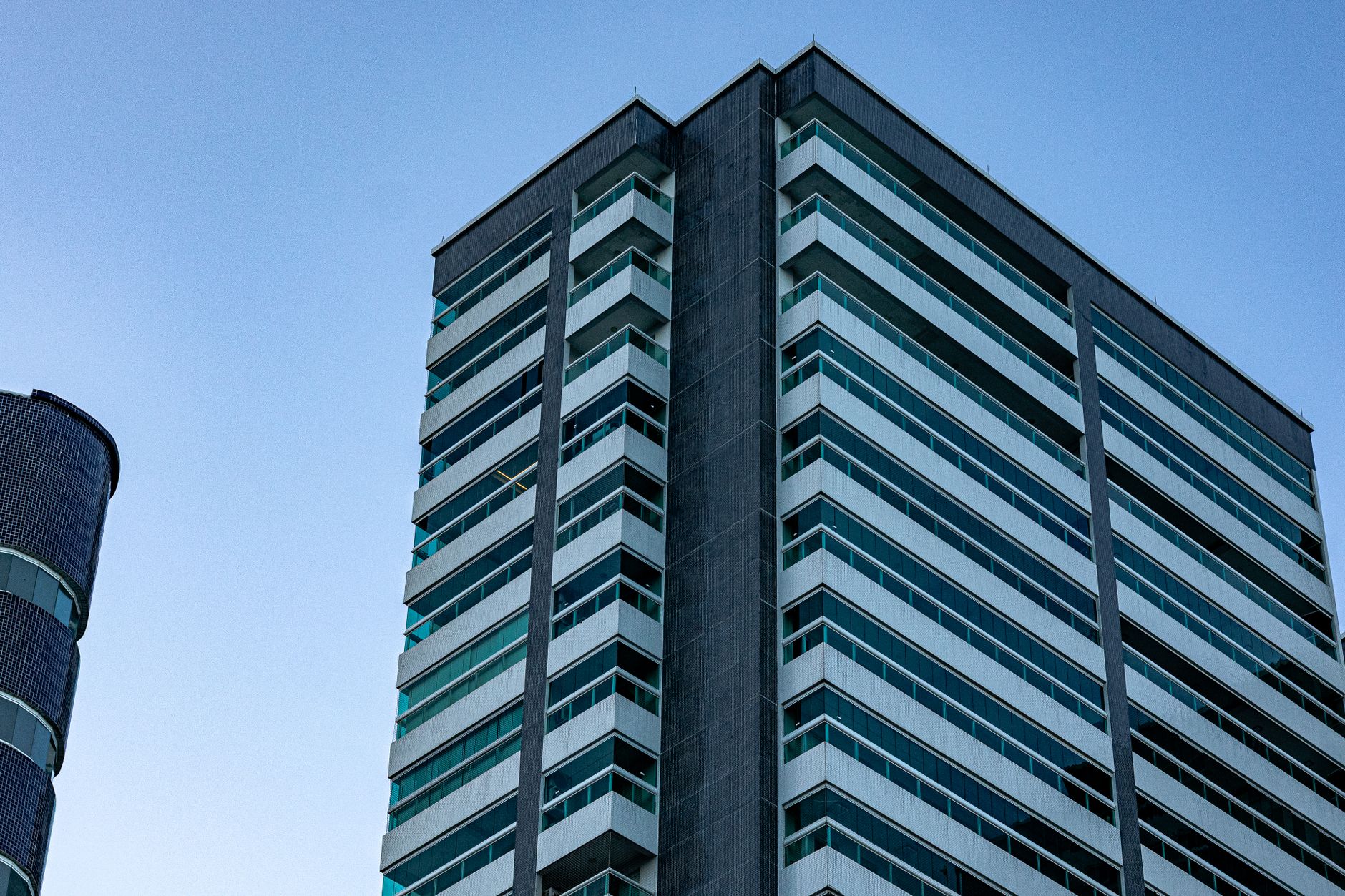 Architectural view of a modern high-rise building against a clear blue sky.