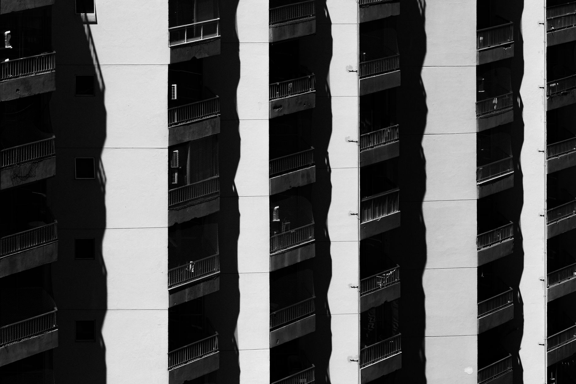 Black and white abstract view of shadows on a tall building facade in Rio de Janeiro, Brazil.