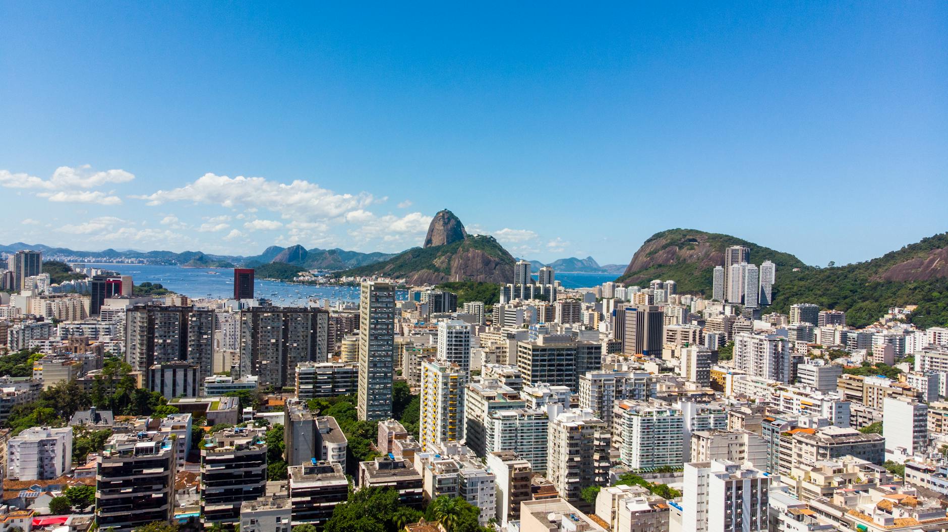 Stunning aerial view of Rio de Janeiro's skyline featuring Sugarloaf Mountain under a clear blue sky.