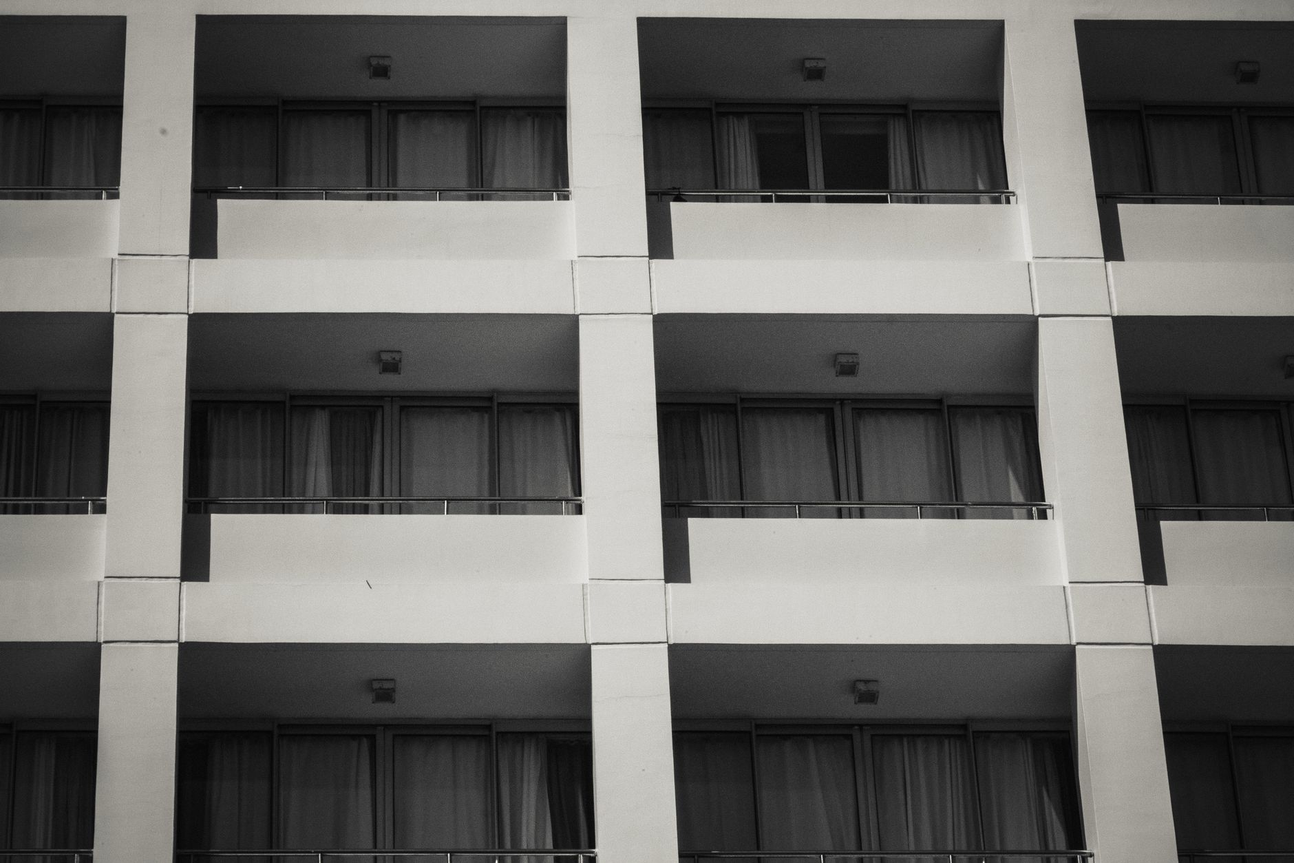 Monochrome image of an apartment facade showcasing balconies and architectural design.