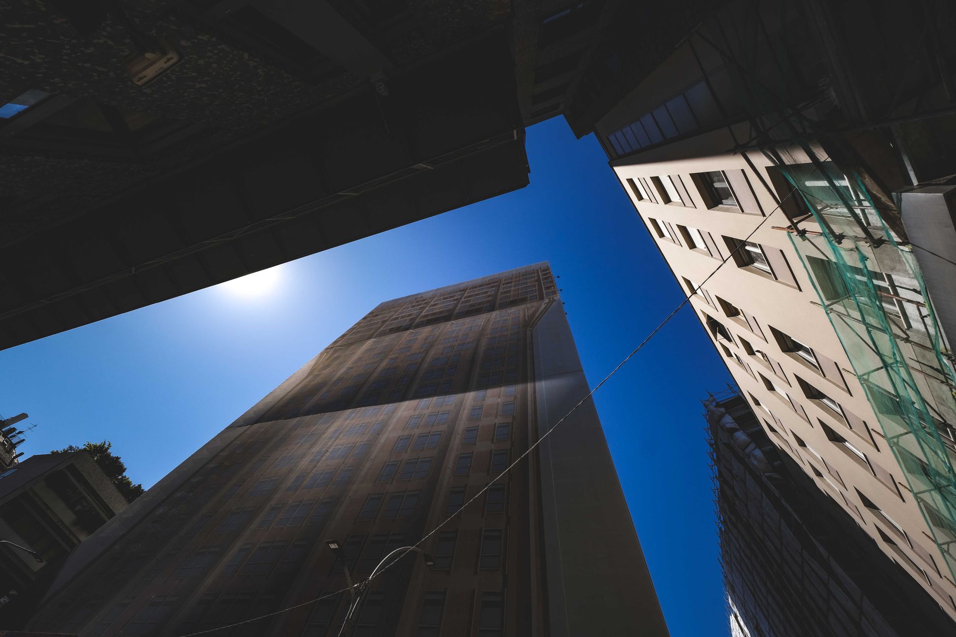 A striking low-angle view of multiple buildings against a vibrant blue sky, capturing urban architecture.