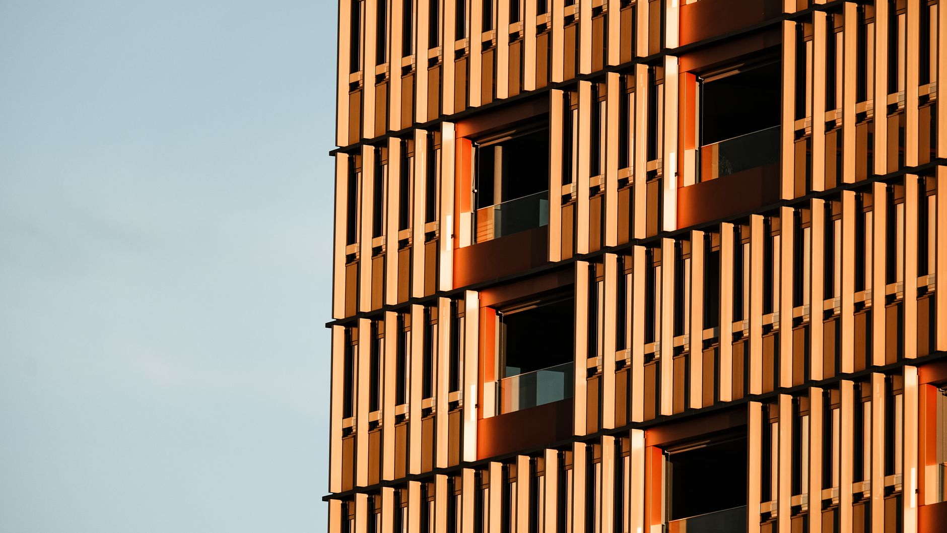 Dynamic view of modern architectural building facade with sunlight reflections highlighting the unique design.