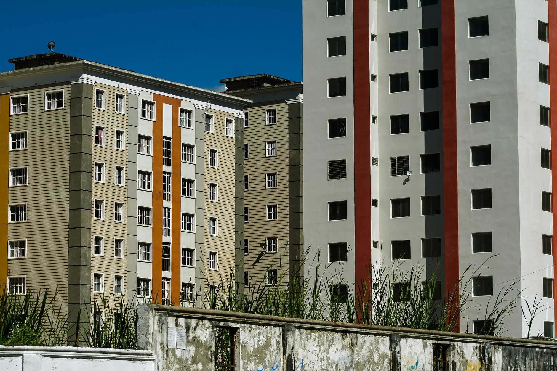 Modern apartment buildings with colorful facades against a clear blue sky in Venezuela.