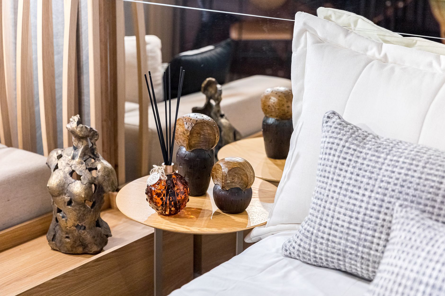 Stylish bedroom in São Paulo with decorative statues and modern bedding, offering a cozy and artistic feel.