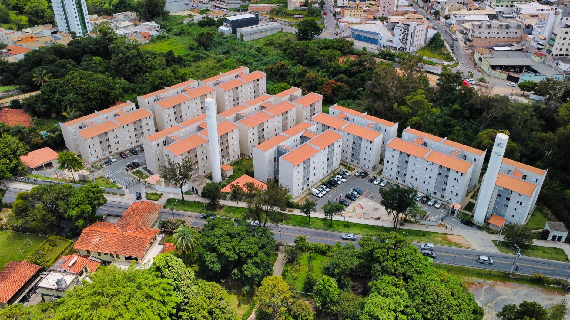 Aerial view showcasing a modern apartment complex surrounded by greenery in MG, Brazil.