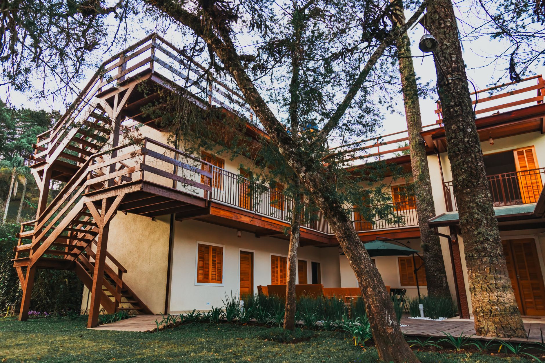 A picturesque wooden terrace house nestled amongst lush trees under a clear sky, capturing the tranquility of nature.