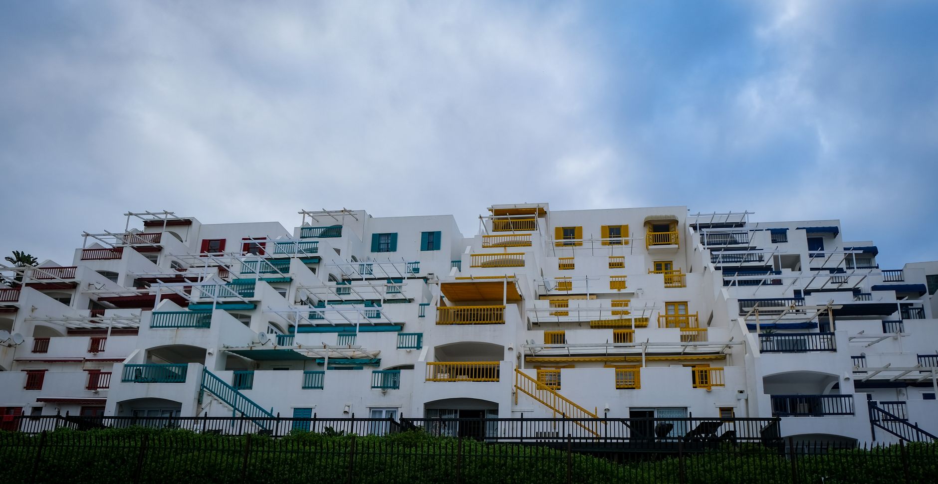 Colorful modern apartment building with a unique design against a cloudy sky.