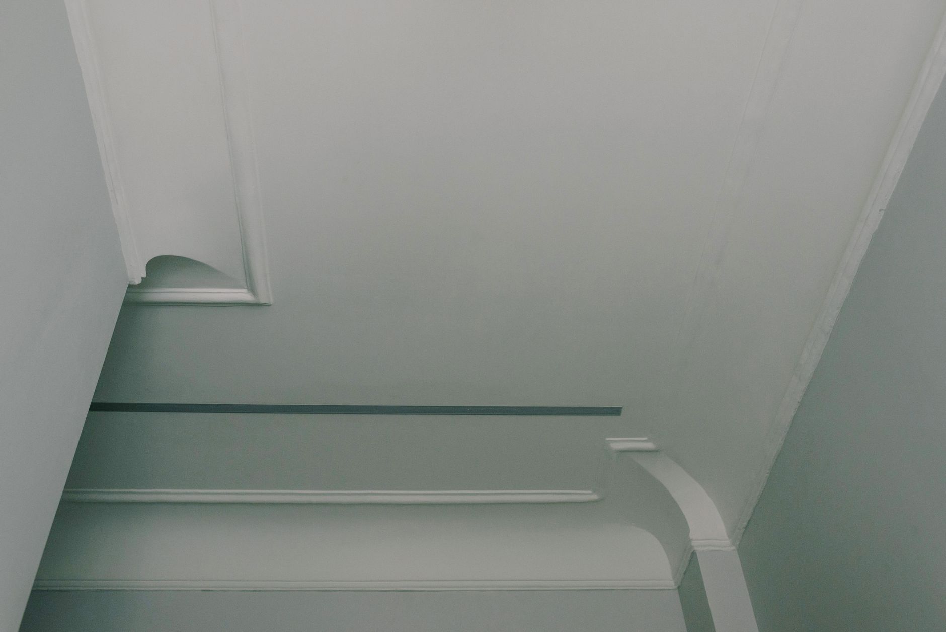 From below of light white ceiling with geometric ornament in stylish apartment in daytime