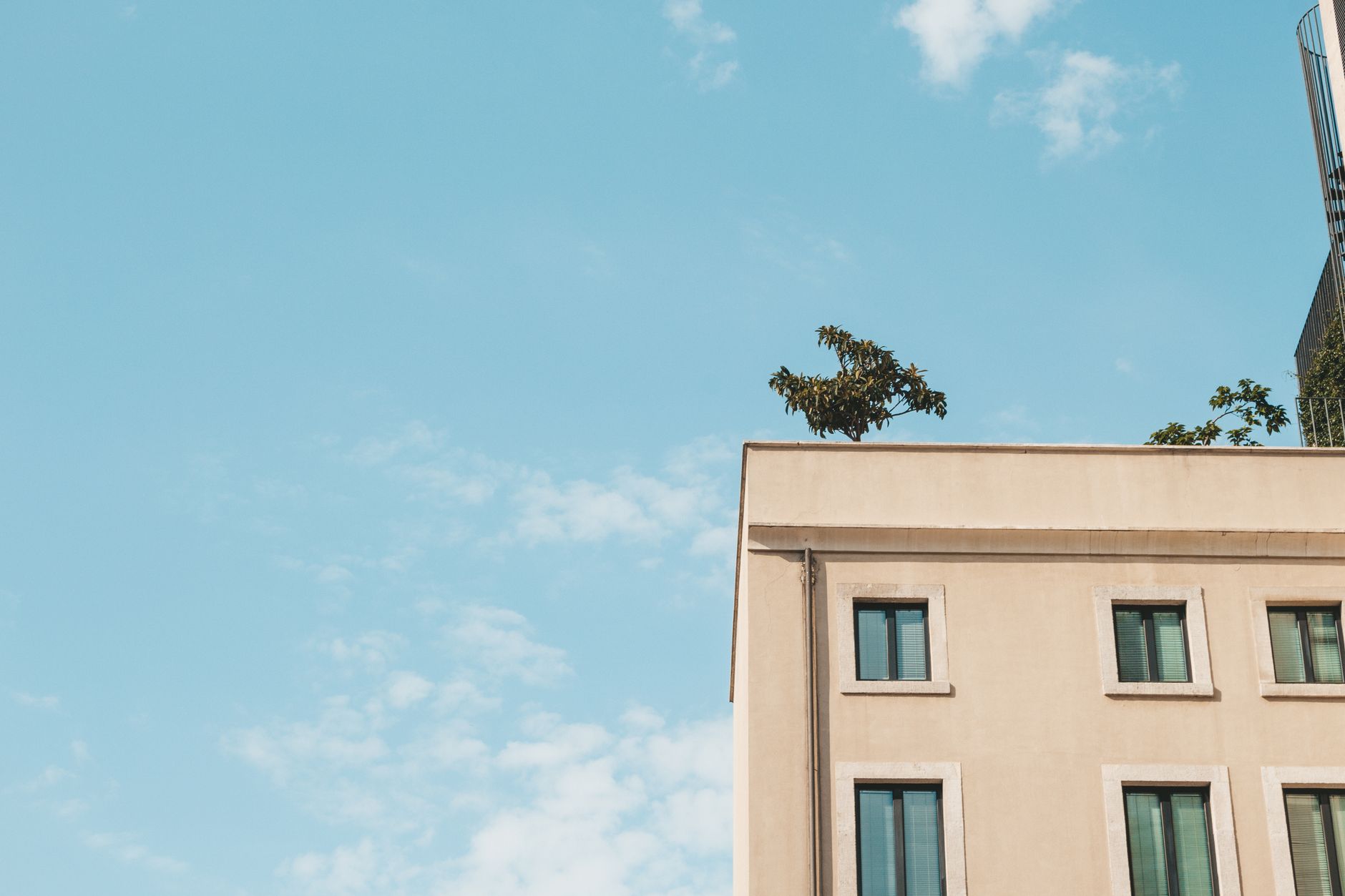 A contemporary building facade with windows set against a clear blue sky, ideal for architectural themes.