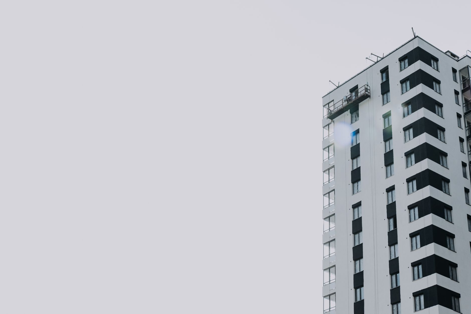 Elegant high-rise residential building set against a clear sky, offering copy space.