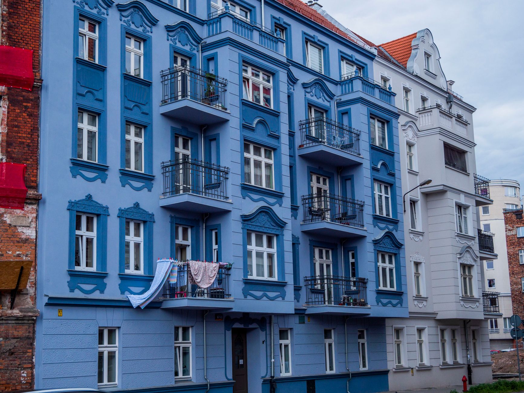 Vibrant blue apartment building in a European city with classic architecture.