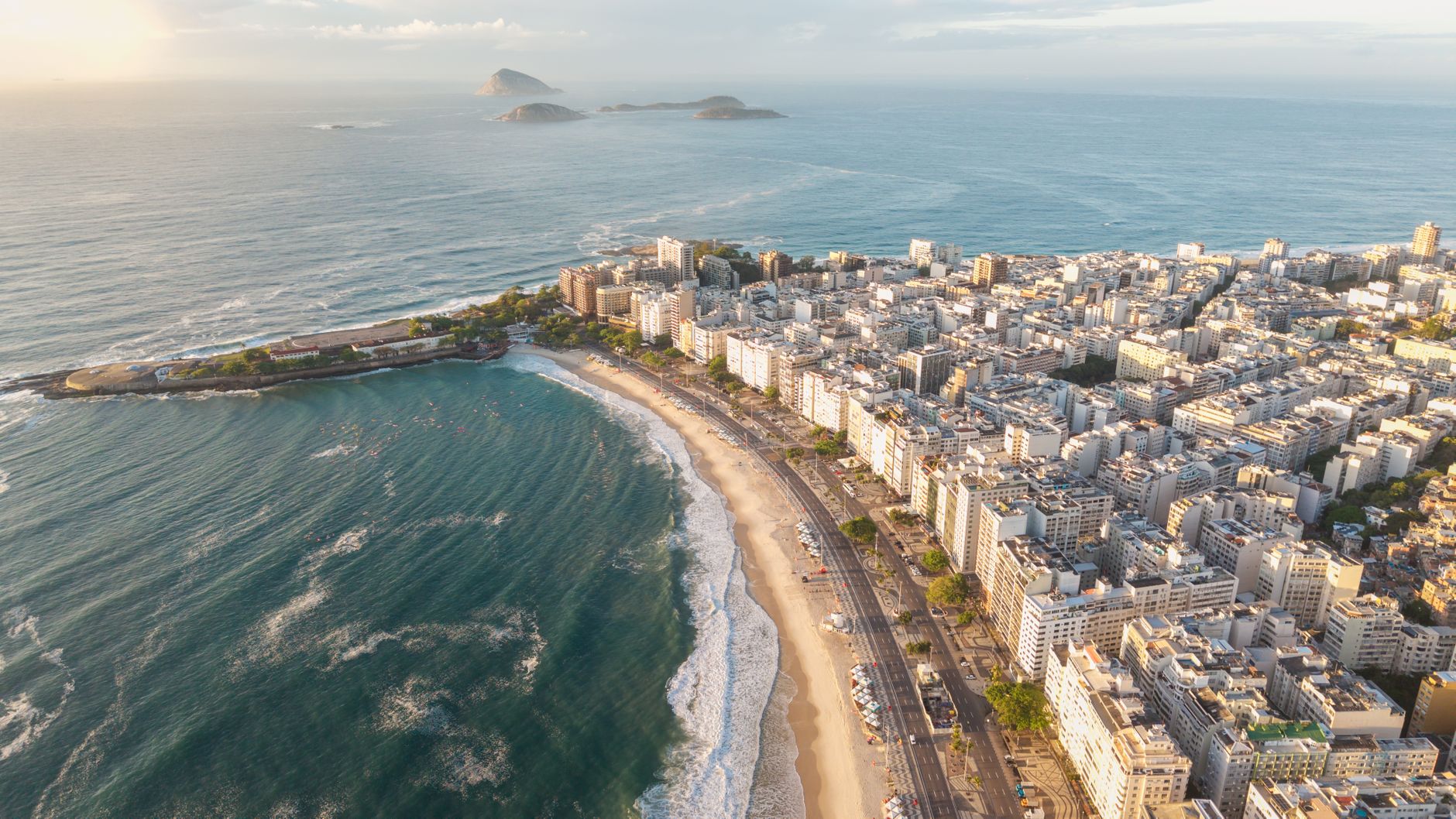 Stunning aerial shot of Copacabana Beach in Rio de Janeiro during golden sunset light.