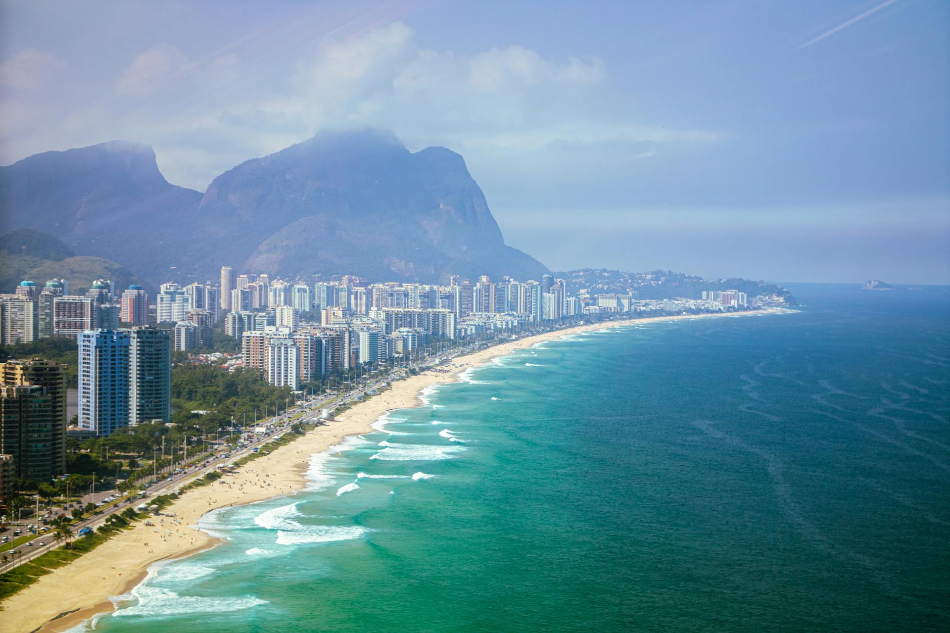 Stunning aerial view of Barra da Tijuca beach with city's skyline and mountains in Rio de Janeiro, Brazil.