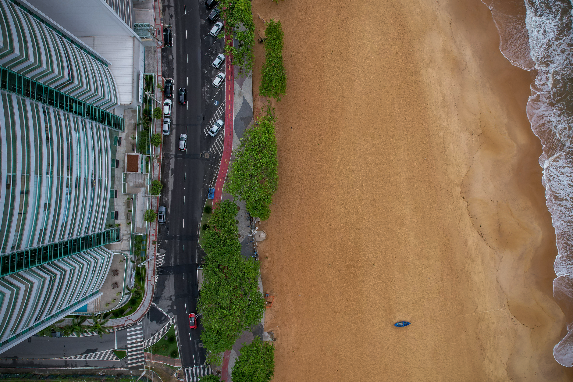 Drone shot capturing Vila Velha's beachfront meeting the urban landscape, showcasing sand, sea, and city life.