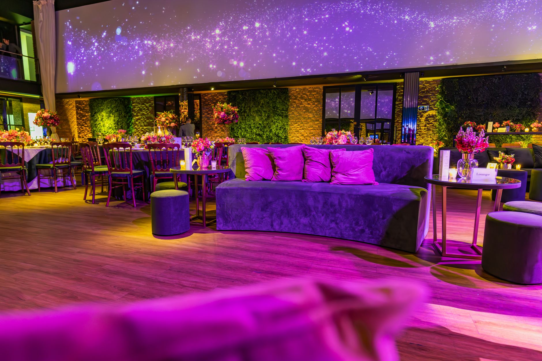Elegant indoor party space with purple lighting and luxurious seating, perfect for events.