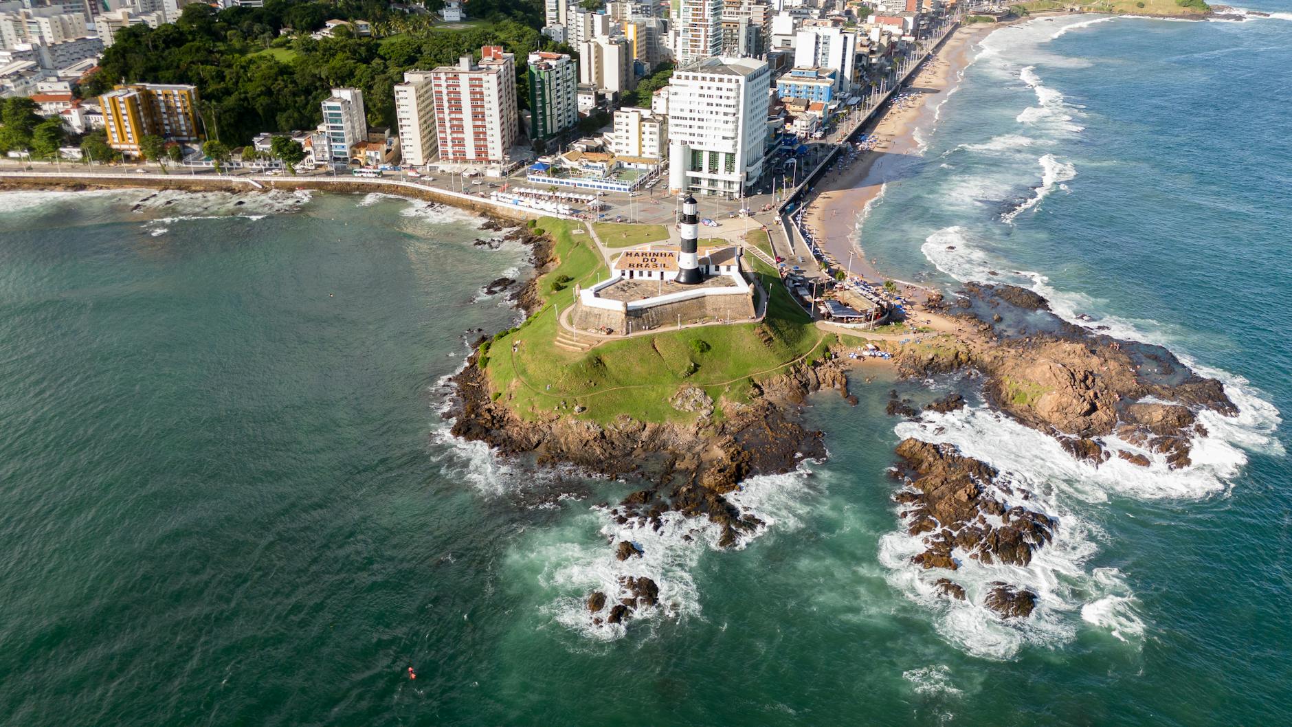A stunning aerial view of Barra Lighthouse in Salvador, capturing the coastline and cityscape.