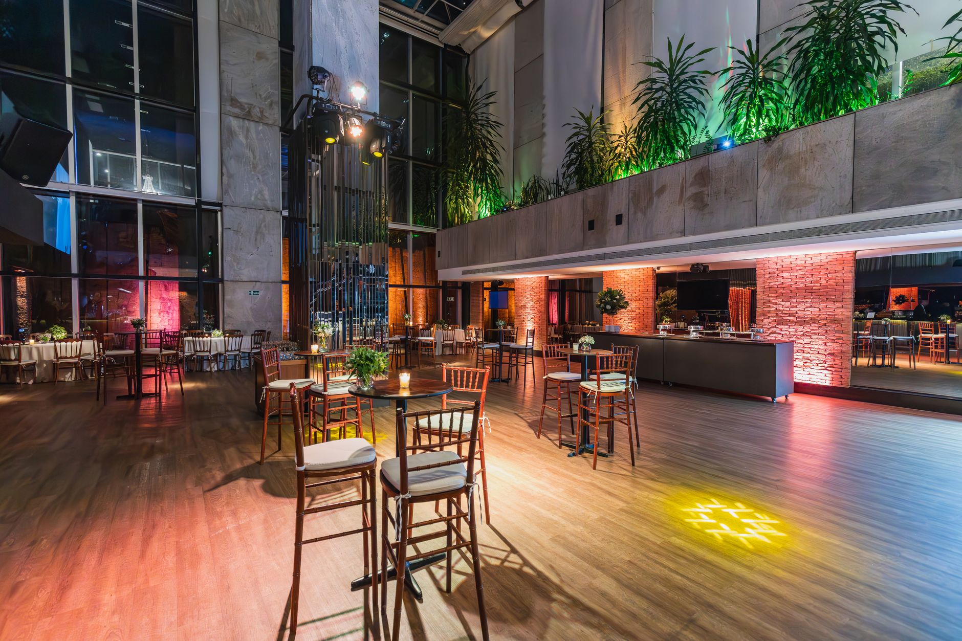 Luxurious modern banquet hall with ambient lighting, wooden floors, and stylish decor.