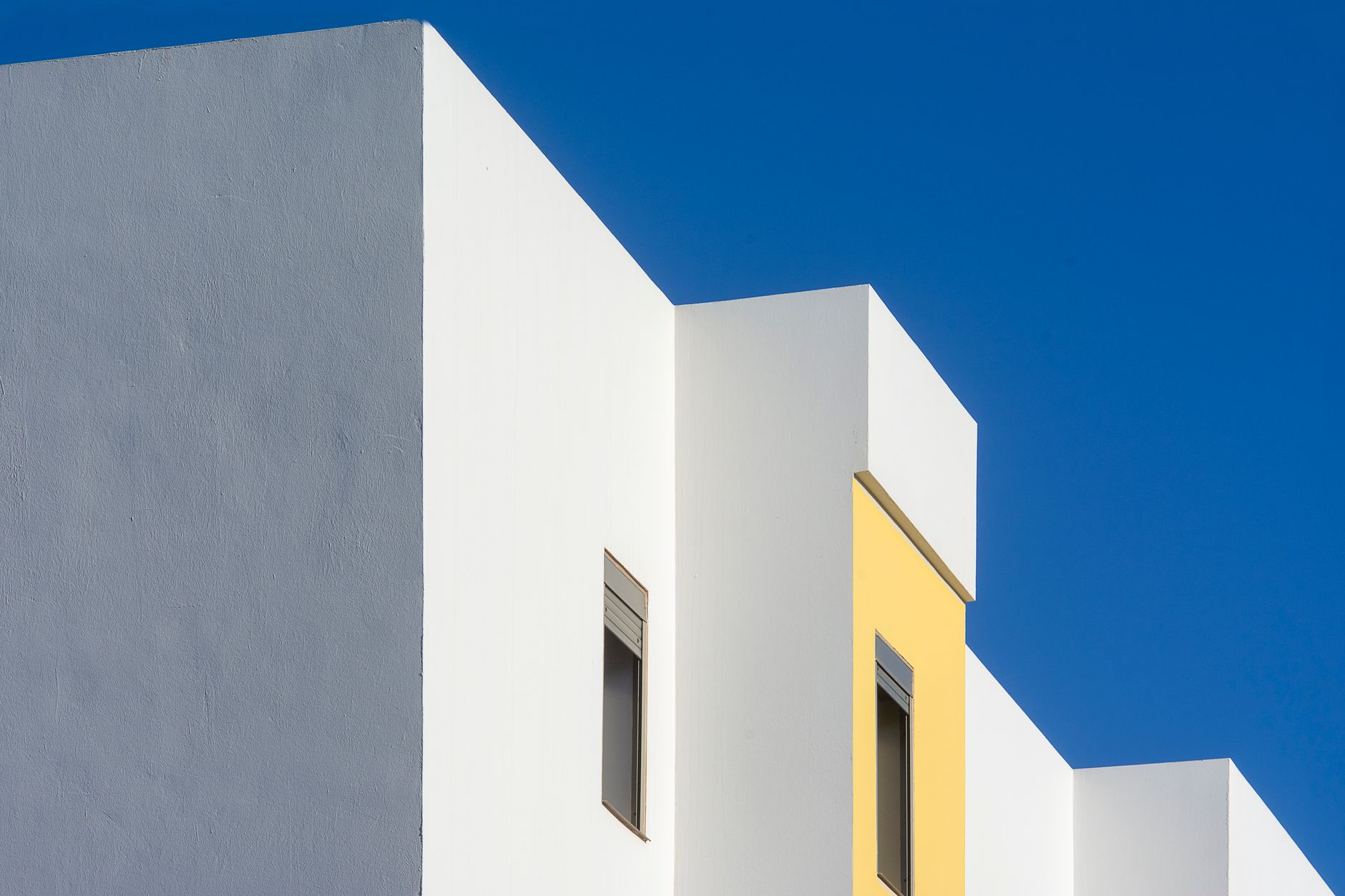 Abstract view of a contemporary building facade with blue sky background.