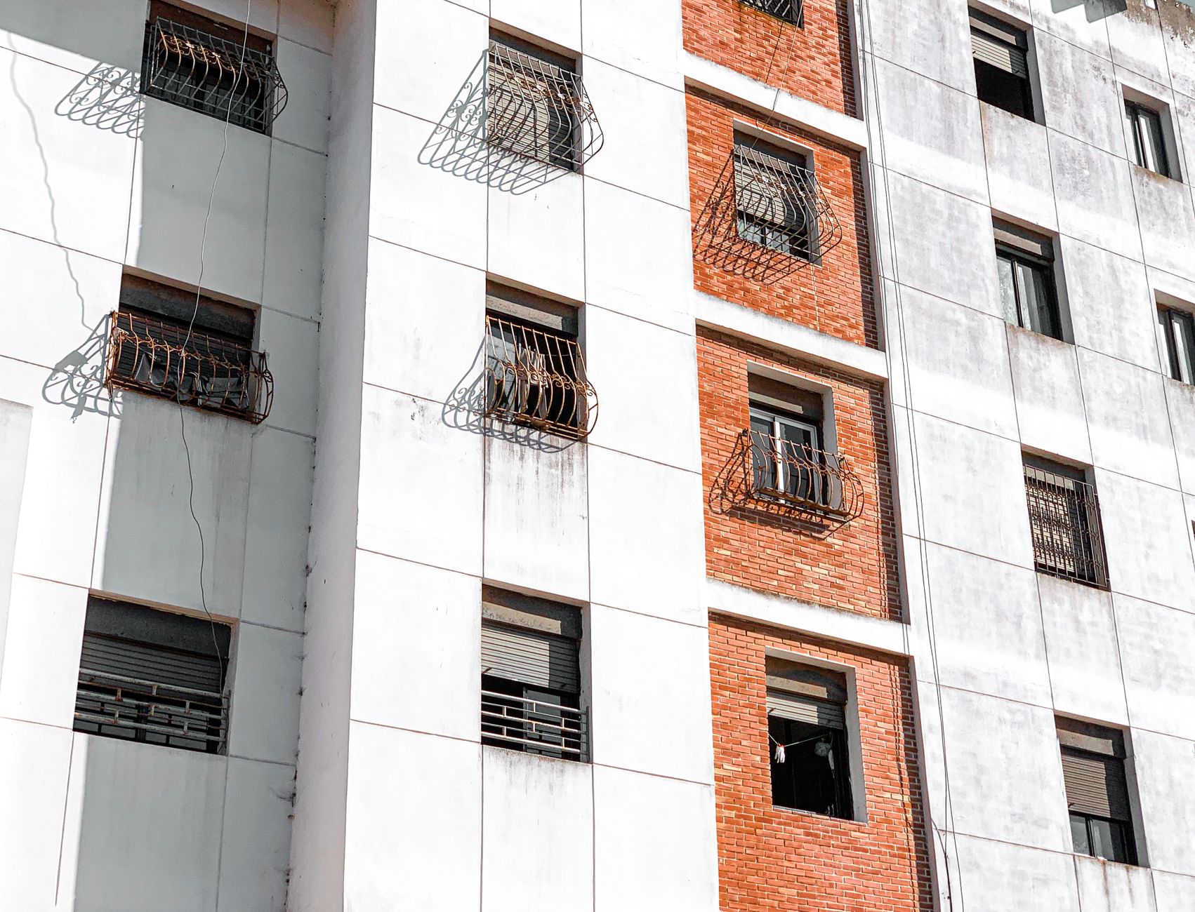 Contemporary urban facade with patterned brick and glass design highlighting modern architecture.