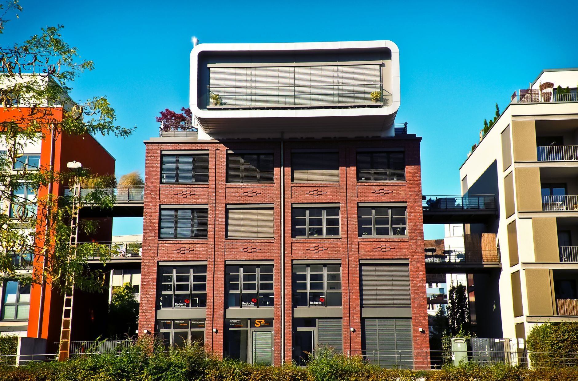 Contemporary brick apartment building with unique geometric shapes under a clear blue sky.