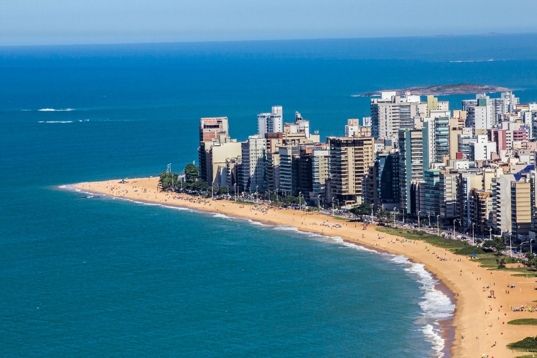 Aerial view of Vila Velha's coastline with skyscrapers and sandy beach, Brazil, vibrant summer scene.