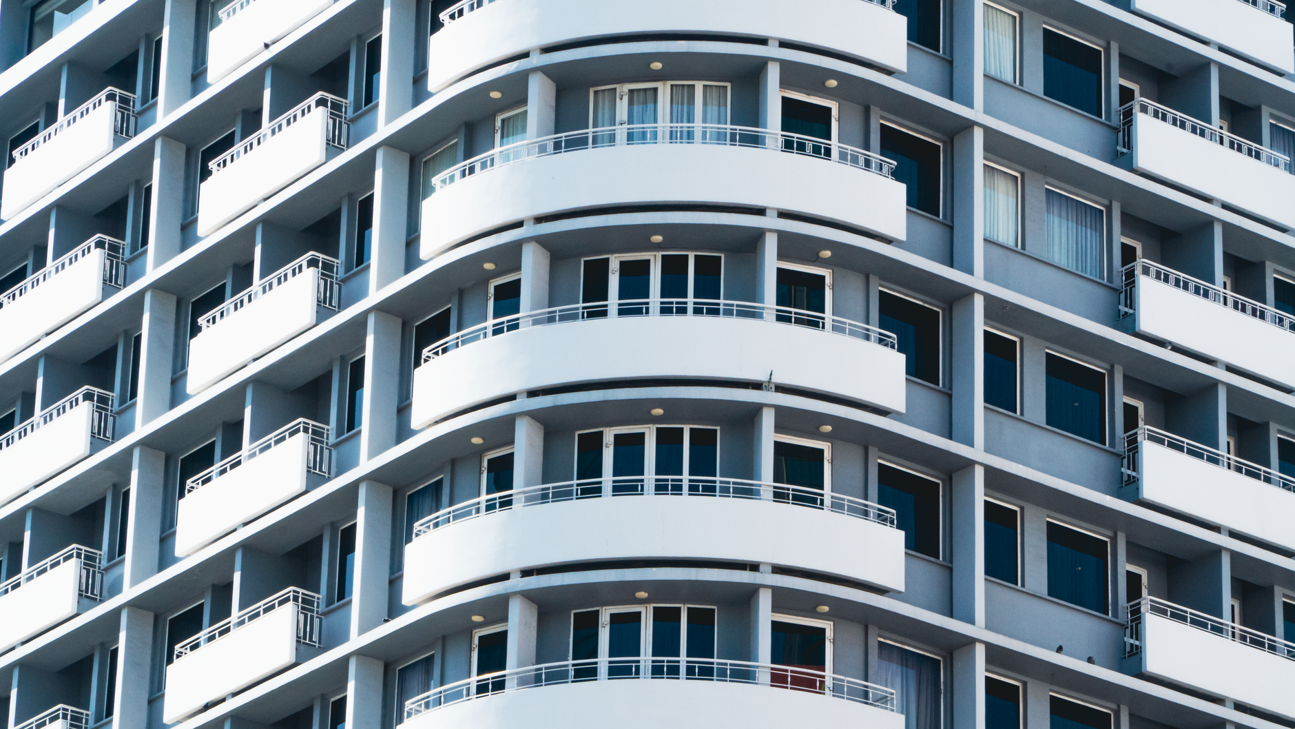 Close-up of curved balconies in a modern urban high-rise building, showcasing architectural design.