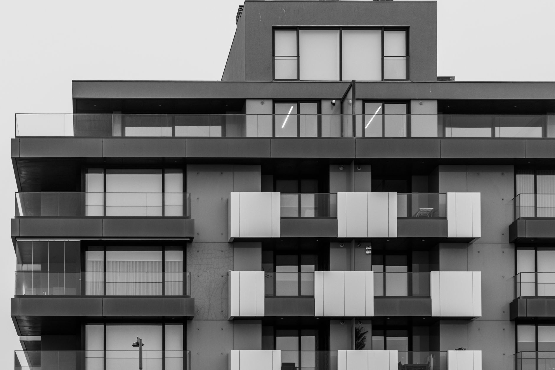 Black and white photo of a modern apartment building showcasing geometric architecture.