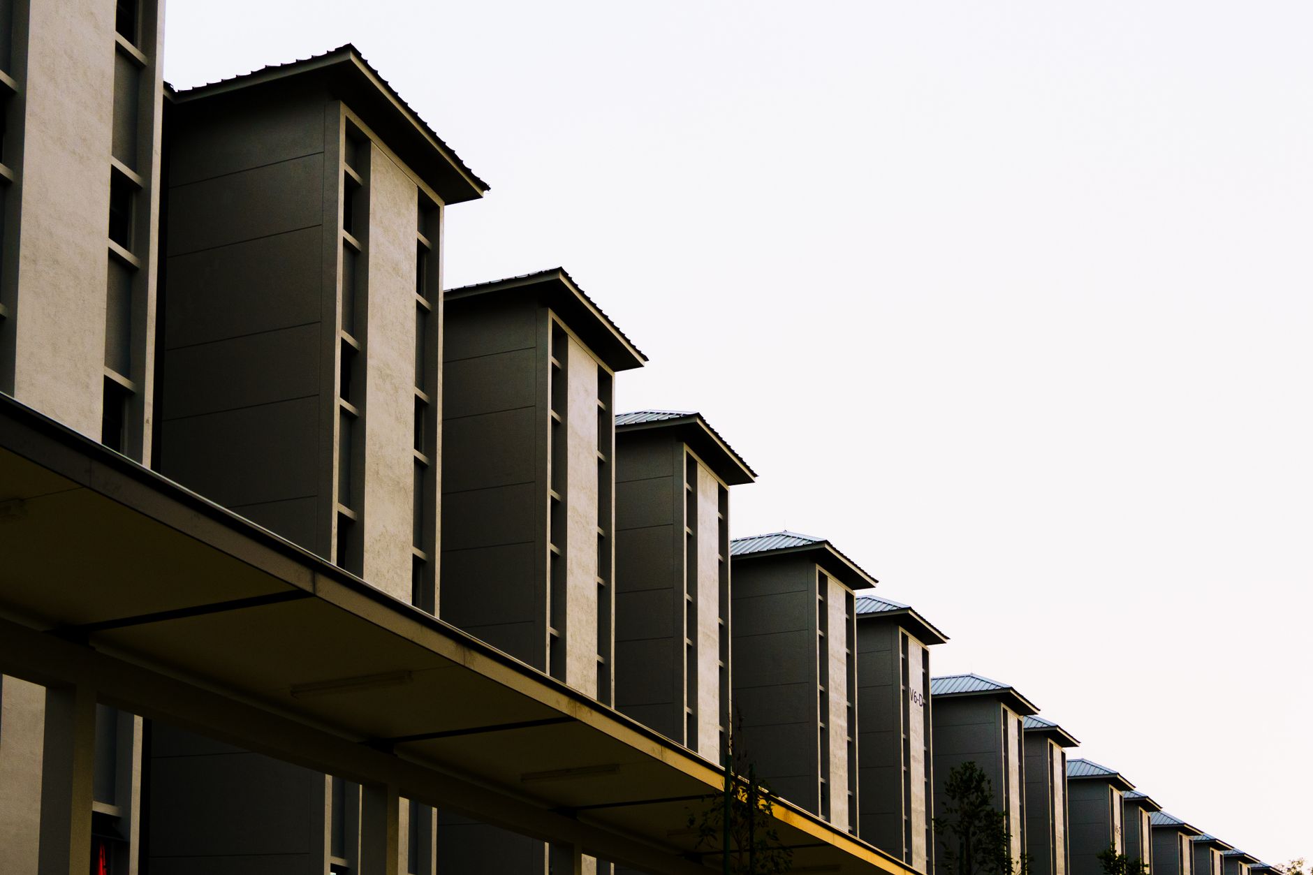 Symmetrical row of modern residential buildings with a minimalist design captured from a low angle.