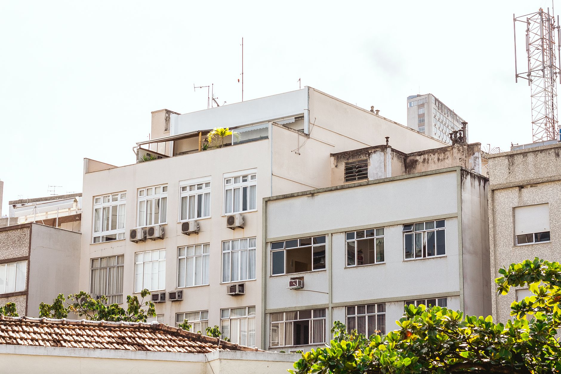 Contemporary residential building facade with air conditioning units in an urban setting.
