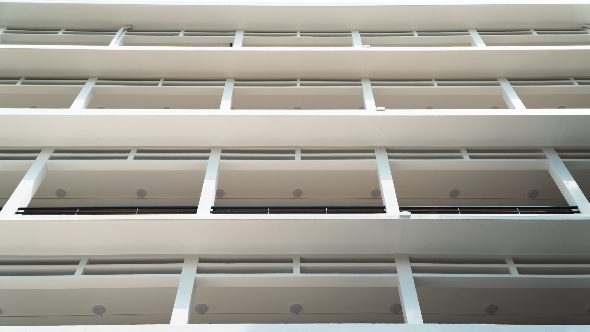 A modern white building showcasing minimalism, clean lines, and repetitive patterns.