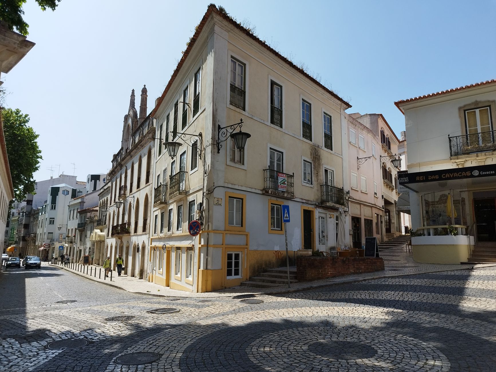 Historic architecture along a sunny cobblestone street in Europe, perfect for travel and urban exploration themes.