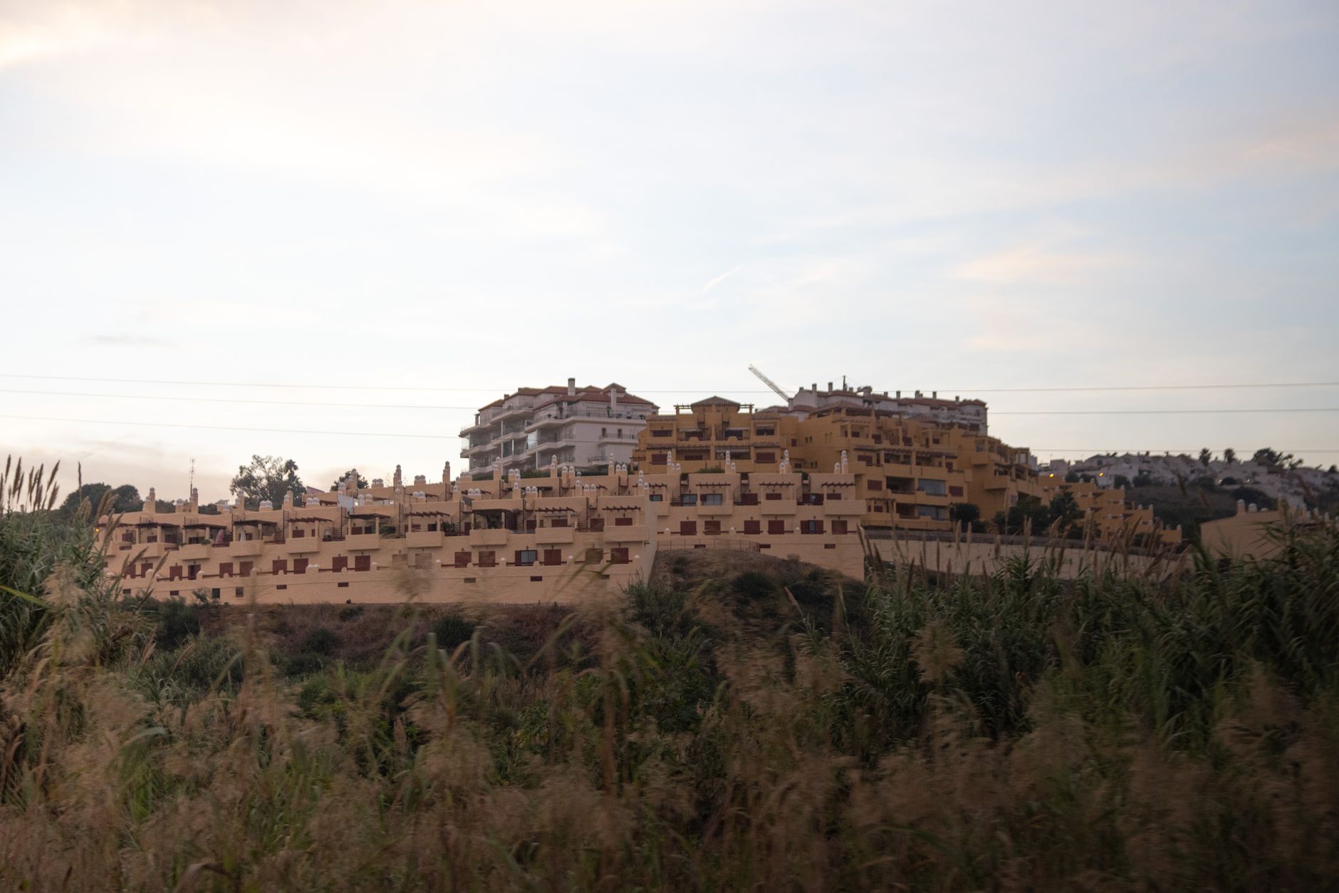 Terracotta residential buildings with natural scenery in Marbella, Spain.
