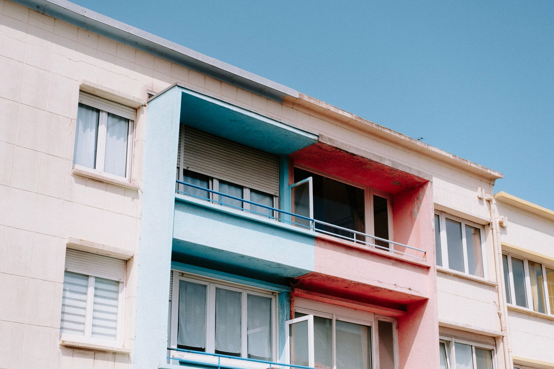 Low angle shot of a building with colorful balconies against a clear sky.
