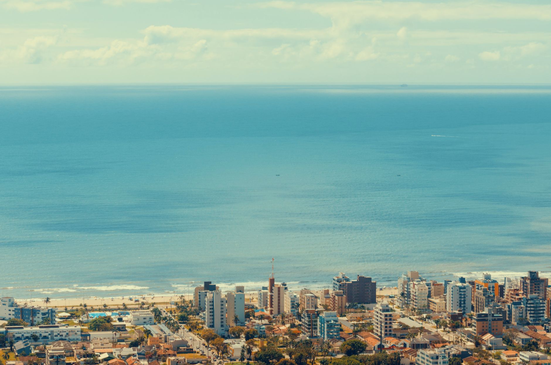Captivating aerial shot of a coastal city with buildings and serene blue ocean.