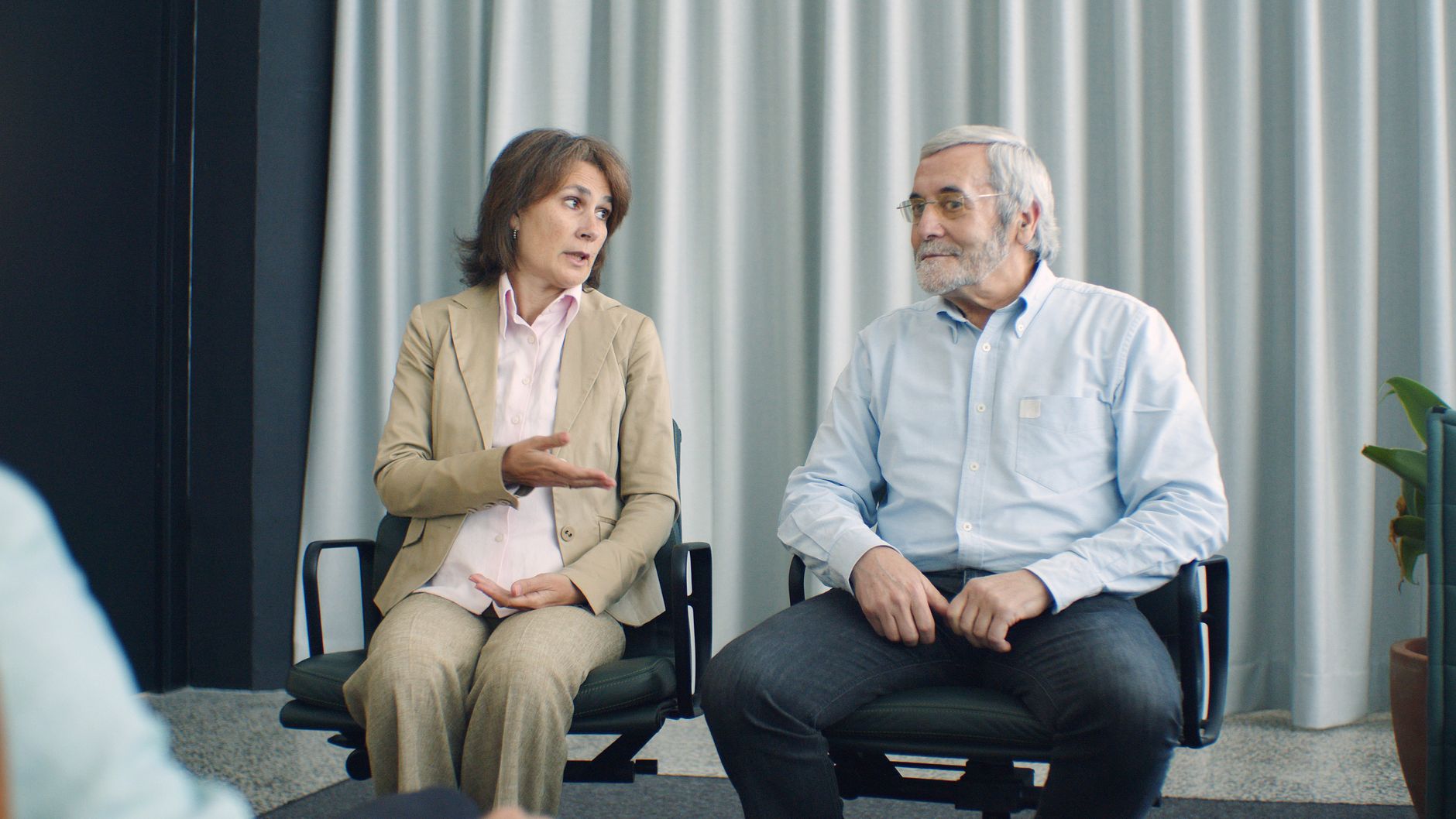 An elderly couple sitting in a counseling session discussing their relationship.