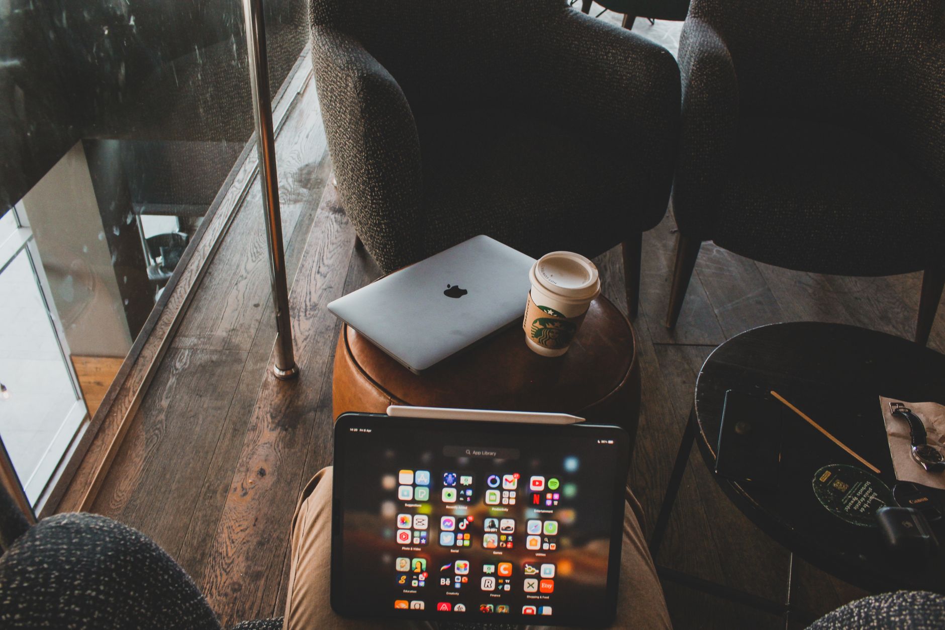 Modern cafe interior with tablets and coffee cup on table, perfect for tech and lifestyle themes.