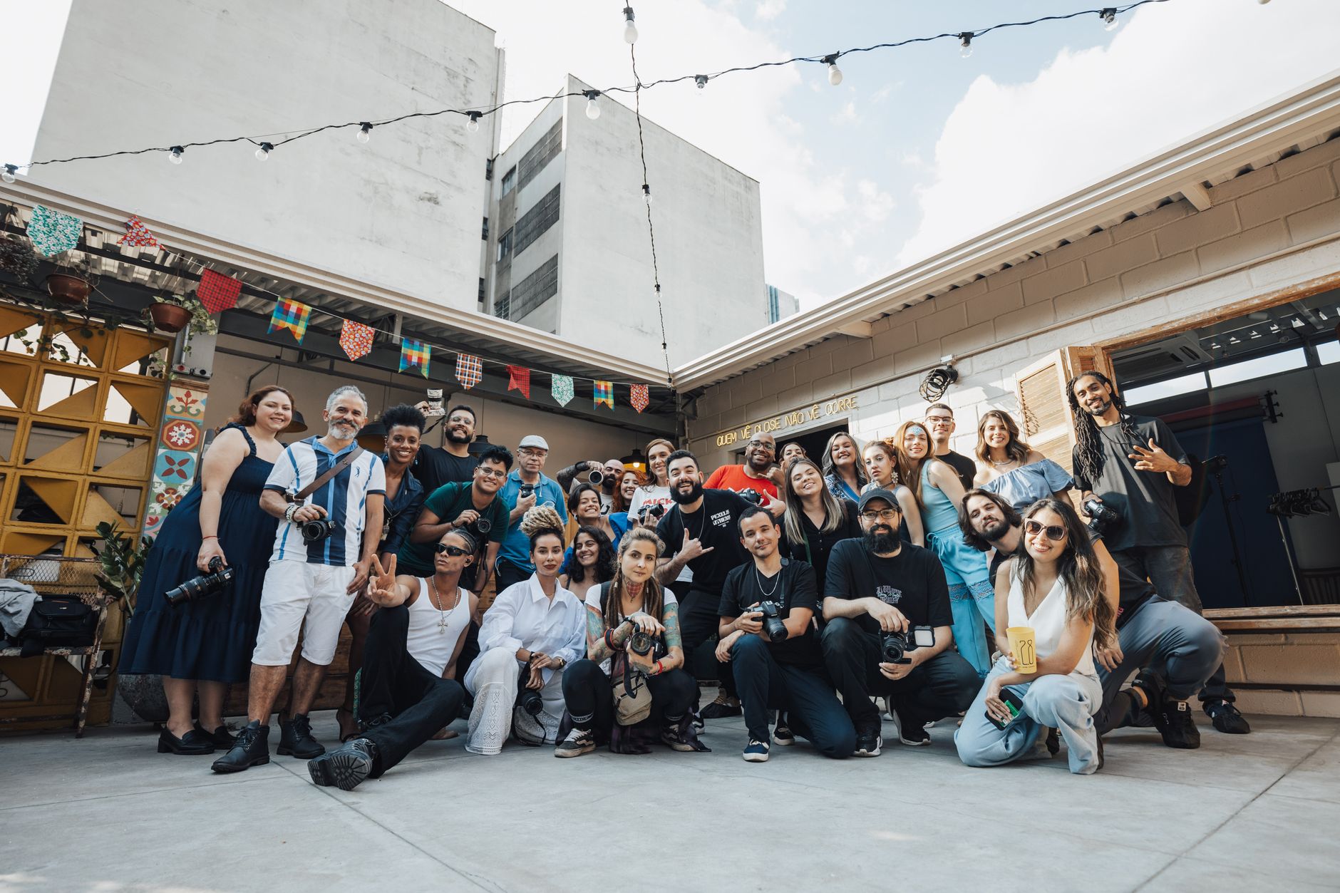Diverse group of photographers posing together in São Paulo, showcasing creativity and community.