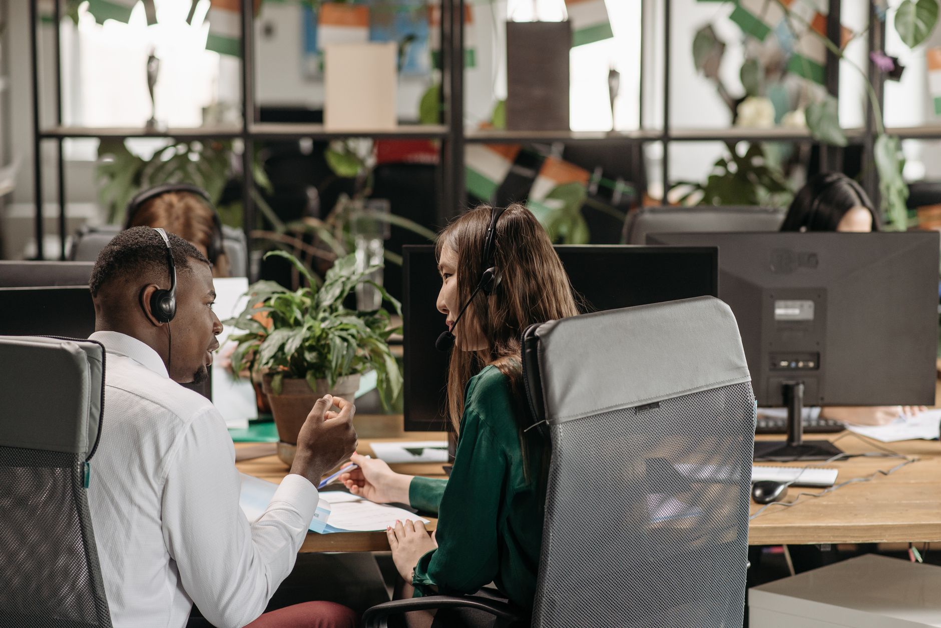Diverse call center agents collaborating in a modern office environment.