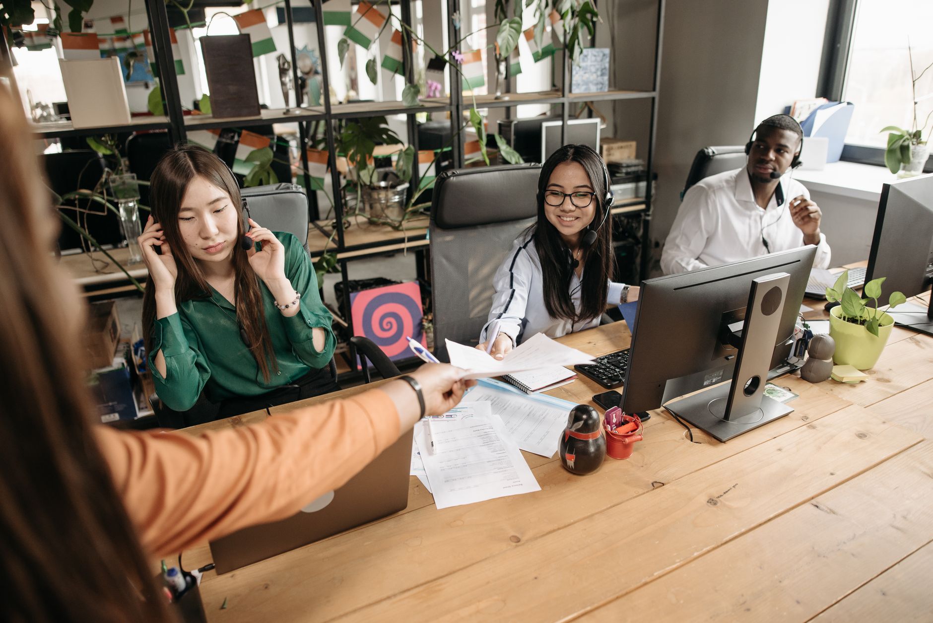 Diverse call center team collaborating at a modern workspace, showcasing teamwork and communication.