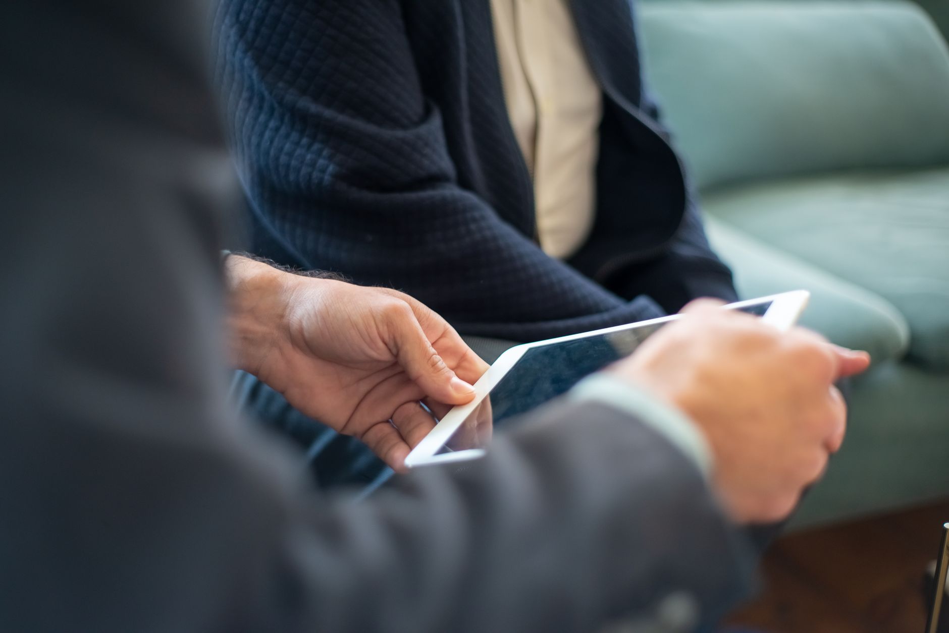 Two business people using a tablet during an indoor meeting. Perfect for tech and collaboration themes.